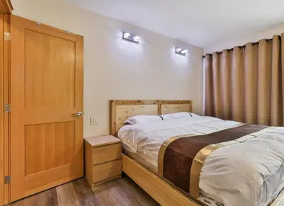 a bedroom with a bed and a wooden door at Riverfront Estate Bed&Breakfast Banff in Banff