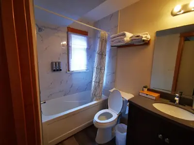 a bathroom with a tub and a toilet and a sink at Riverfront Estate Bed&Breakfast Banff in Banff
