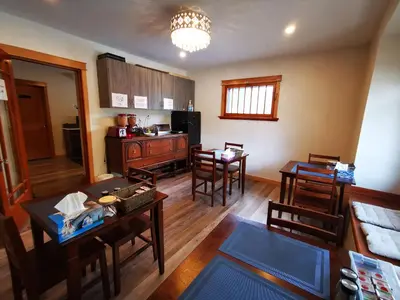 a living room with tables and chairs and a kitchen at Riverfront Estate Bed&Breakfast Banff in Banff