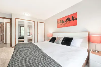 a bedroom with a large white bed with two lamps at The Best ski-in/ski-out at The Aspens in Whistler