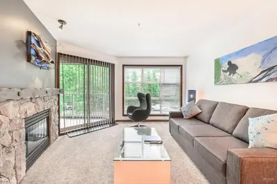 a living room with a couch and a fireplace at The Best ski-in/ski-out at The Aspens in Whistler