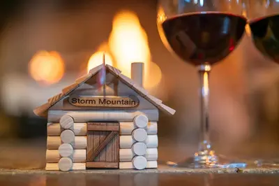 a small house with a candle and a glass of wine at Storm Mountain Lodge & Cabins in Banff