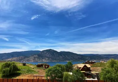 a view of a lake with mountains in the background at Wesbert Winery & Guest Suites in Penticton