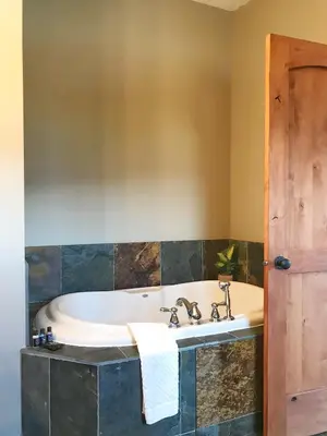 a bath tub in a bathroom with a sink at Wesbert Winery & Guest Suites in Penticton