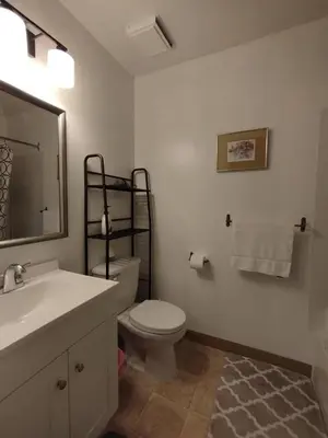 a bathroom with a toilet and a sink and a mirror at Jenny Guest House in Yellowknife