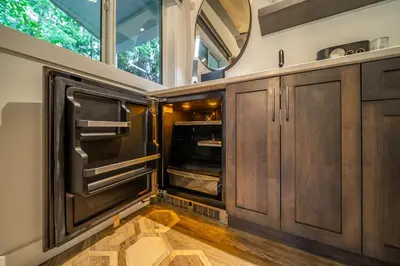 a kitchen with wooden cabinets and an open oven at Halcyon Hot Springs Resort in Halcyon Hot Springs