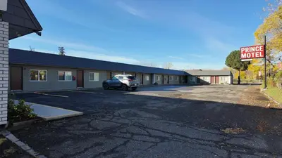 a parking lot in front of a building with a parking meter at Prince Motel in Prince George