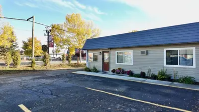 a house with a parking lot in front of it at Prince Motel in Prince George