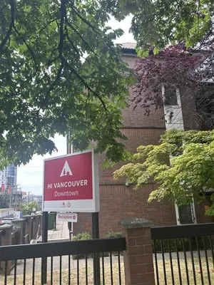 a sign on a fence in front of a building at HI Vancouver Downtown - Hostel in Vancouver