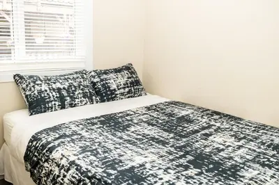 a bedroom with a bed with a black and white comforter at Crescent Motel in Radium Hot Springs