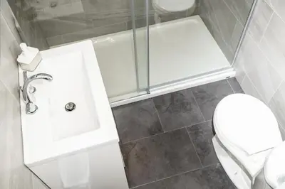 a small bathroom with a toilet and a shower at Crescent Motel in Radium Hot Springs