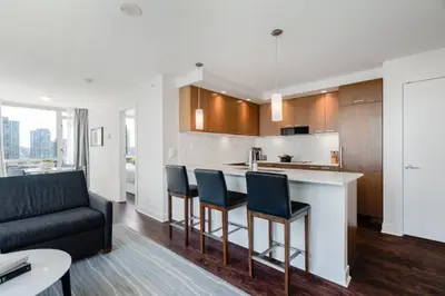 a kitchen and living room with a bar and a couch at Level Vancouver Yaletown - Seymour in Vancouver