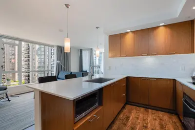 a kitchen with wooden cabinets and a counter top at Level Vancouver Yaletown - Seymour in Vancouver
