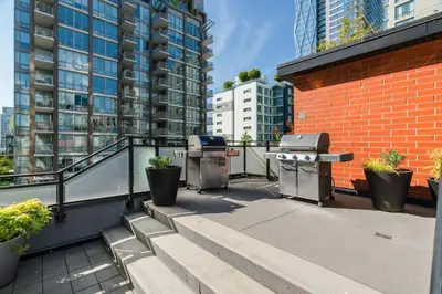 a balcony with a grill and a brick building at Level Vancouver Yaletown - Seymour in Vancouver