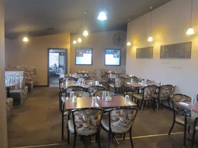 a dining room with wooden tables and chairs at Battlefords Inn in North Battleford
