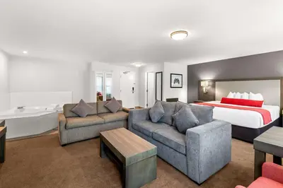 a hotel room with a bed and a couch and chairs at Best Western Cowichan Valley Inn in Duncan