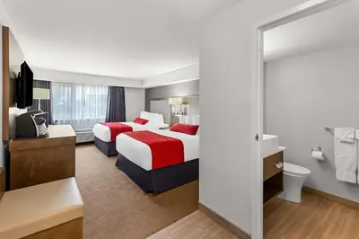 a hotel room with two beds and a bathroom at Best Western Cowichan Valley Inn in Duncan