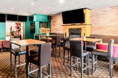a restaurant with tables and chairs and a flat screen tv at Best Western Cowichan Valley Inn in Duncan