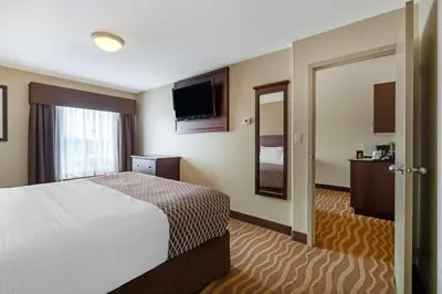 a hotel room with a bed and a television at Best Western High Road Inn in Edson