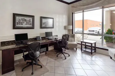 a office with a desk with three computers and chairs at Best Western High Road Inn in Edson