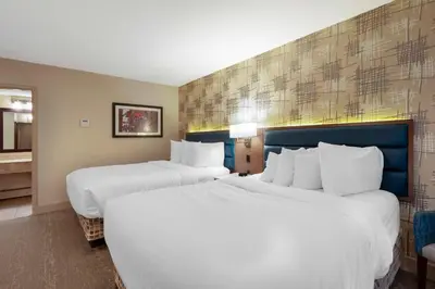 a hotel room with two beds and a bathroom at Best Western PLUS City Centre Inn in Edmonton