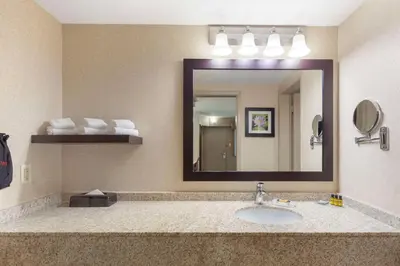 a bathroom with a sink and a large mirror at Best Western PLUS City Centre Inn in Edmonton