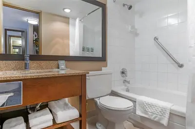 a bathroom with a toilet and a sink and a tub at Best Western Terrace Inn in Terrace
