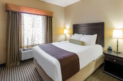 a hotel room with a large bed and a window at Best Western Sunrise Inn & Suites in Stony Plain
