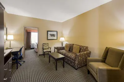 a hotel room with a couch and a desk at Best Western Sunrise Inn & Suites in Stony Plain