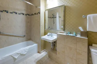a bathroom with a tub and a sink and a toilet at Best Western Sunrise Inn & Suites in Stony Plain