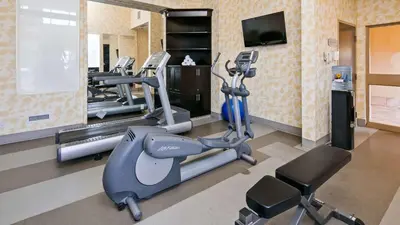 a gym with several tread machines and a television at Best Western Sunrise Inn & Suites in Stony Plain