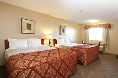 a hotel room with two beds and a window at Bow River Inn in Cochrane
