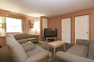 a living room with two couches and a television at Bow River Inn in Cochrane