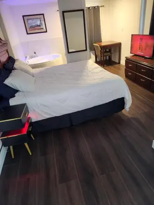 a bedroom with a large bed and a television at Cache Creek Inn in Cache Creek