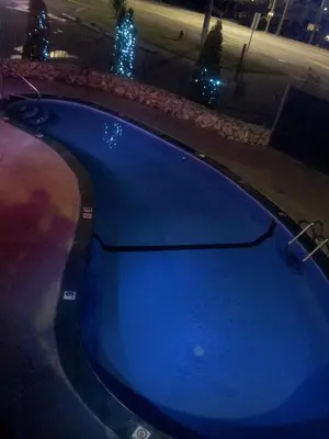 a large blue swimming pool at night with lights at Cache Creek Inn in Cache Creek