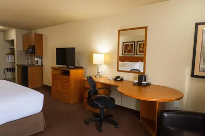 a hotel room with a desk and a bed and a room at Canalta Provost in Provost