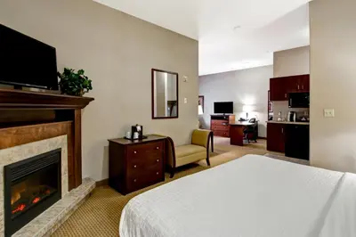 a hotel room with a bed and a fireplace at Canalta Oyen in Oyen