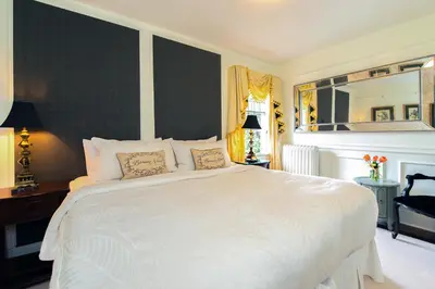 a bedroom with a large white bed with pillows at The Craigmyle Inn in Victoria