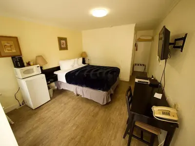 a hotel room with a bed and a desk at Creston Valley Motel in Creston