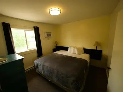 a hotel room with a bed and a window at Creston Valley Motel in Creston