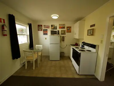 a small kitchen with a stove and a table at Creston Valley Motel in Creston