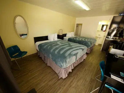 a hotel room with two beds and a mirror at Creston Valley Motel in Creston