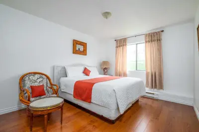 a bedroom with a bed and a chair and a window at Croft Inn Motel in Crofton