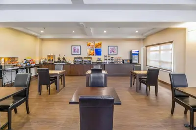 a restaurant with tables and chairs and a counter at Comfort Inn in Dawson Creek
