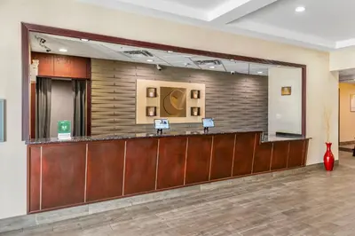 a lobby with a waiting area with a large mirror at Comfort Inn in Dawson Creek