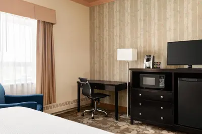 a hotel room with a desk and a television at Nova Inn Yellowknife in Yellowknife