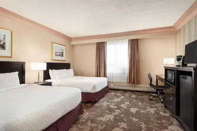a hotel room with two beds and a television at Nova Inn Yellowknife in Yellowknife