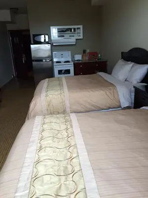 a hotel room with two beds and a refrigerator at Days Inn by Wyndham Athabasca in Athabasca