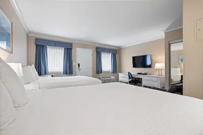 a hotel room with two beds and a desk at Glenwood Inn & Suites in Trail