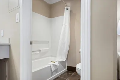 a bathroom with a white tub and a toilet at Glenwood Inn & Suites in Trail